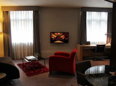 Im Haus, Inneneinrichtung, Wand, Zimmer, Szene, Boden, Vorhang, Couch, Bude, Fensterausstattung, Wohnzimmer, Kissen, Studiocouch, Tisch, Bettsofa, Fensterabdeckung, Kaffeetisch, Stuhl, Kleines Sofa, Haus, Fußboden, Lampenschirm, Fenster, Vase, Clubsessel, Fernsehen, Hotel, Decke, Sofa, Mobiliar, rot, Wohnung