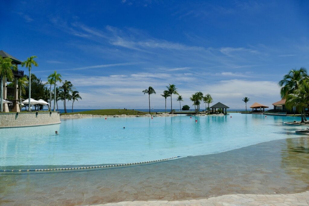 draußen, Baum, Himmel, Palme, Wolke, Wasser, Tropen, Urlaubsort, Karibik, Urlaubsstadt, Schwimmbecken, Palmen, Küstenerholungsort, Strand, Küste, Gewässer, Kurort, Attalea speciosa, Blau, Gelände, Natur, Urlaub, Insel, Pool, Schwimmen