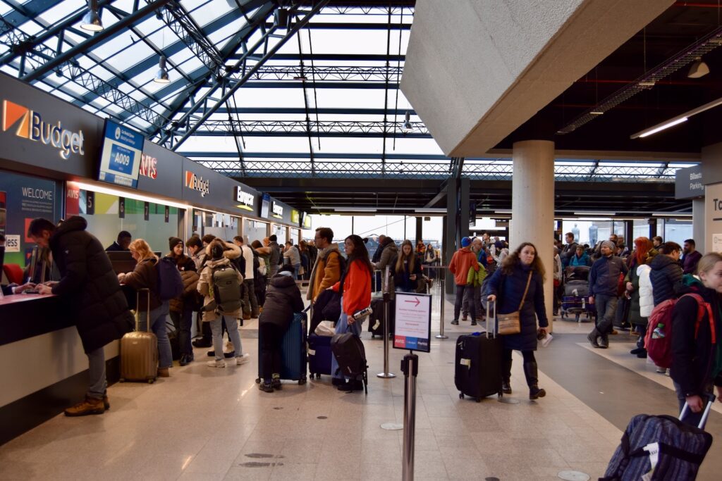 Kleidung, Schuhwerk, Im Haus, Gepäck, Person, Gepäck und Koffer, Mann, Menschen, Decke, Einkaufszentrum, Flughafen, Check-In, Einkaufen, Dienstleistung, Frau, Gepäckabholung, Boden, Gruppe, wartend, stehend