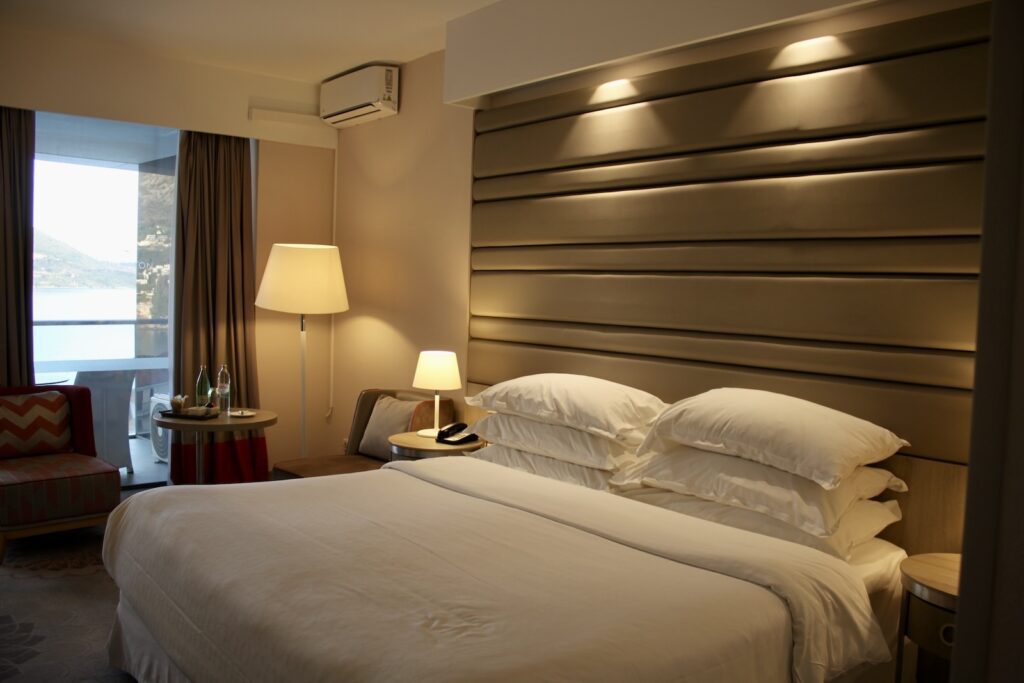 Im Haus, Wand, Inneneinrichtung, Mobiliar, Bettwäsche, Kissen, Bettdecke, Bettbezug, Matratze, Bettrahmen, Nachttisch, Leinenstoffe, Lampenschirm, Bett, Suite, Schlafzimmer, Schublade, Fensterausstattung, Lampe, Boutique-Hotel, Kommode, Fensterabdeckung, Fenster, Bettbehang, Zimmer, Vorhang, Hotel, Boden, Decke