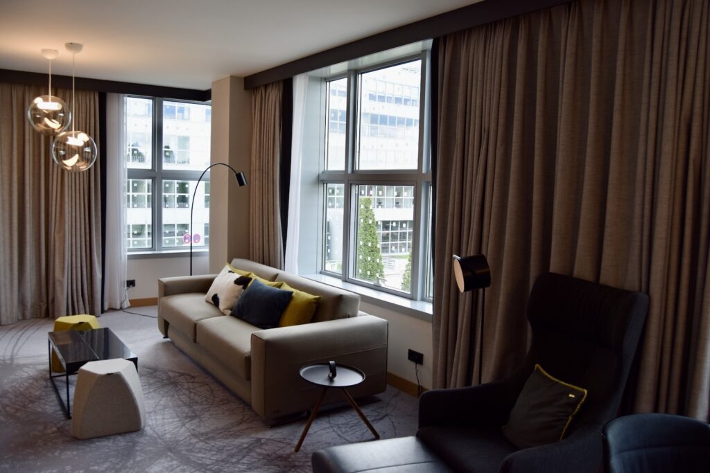 Im Haus, Inneneinrichtung, Fenster, Wand, Fensterausstattung, Boden, Couch, Fensterabdeckung, Kissen, Bettsofa, Studiocouch, Bude, Kleines Sofa, Vorhang, Fußboden, Tisch, Penthouse, Kaffeetisch, Zimmer, Armlehne, Haus, Jalousie, Leinenstoffe, Clubsessel, Hotel, Wohnzimmer, Decke, Sofa, Mobiliar