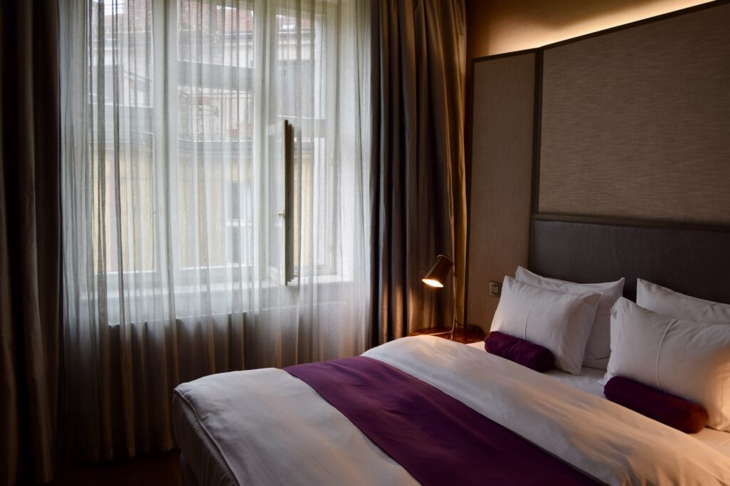 Im Haus, Kissen, Bettwäsche, Wand, Inneneinrichtung, Leinenstoffe, Bettdecke, Bett, Bettbezug, Matratze, Fensterausstattung, Bettrahmen, Vorhang, Fensterabdeckung, Mobiliar, Suite, Fenster, Boutique-Hotel, Nachttisch, Lampenschirm, Zimmer, Decke, Textil, Schlafzimmer, Bettbehang, Hotel