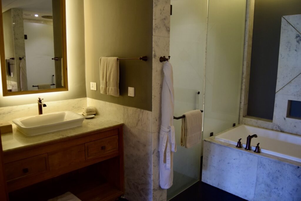 Im Haus, Wand, Installationszubehör, Badezimmerzubehör, Hahn, Wasserleitung, Badezimmer, Kachel, Badezimmerschrank, Spiegel, Waschbecken, Inneneinrichtung, Arbeitsfläche, Zimmer, Boden, Wanne, Dusche, Eitelkeit, Badewanne, Hotel