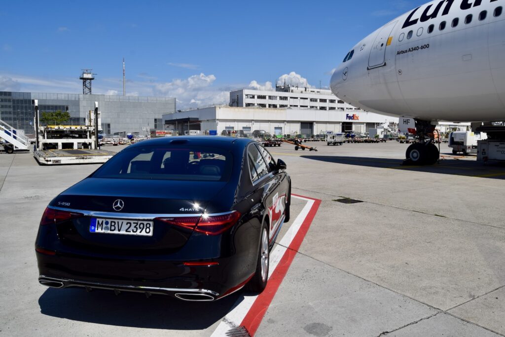 Fahrzeug, Text, draußen, Landfahrzeug, Himmel, Rad, Platane Flugzeug Hobel, mittelgroßes Auto, Reifen, Sportsedan, Kraftfahrzeugkennzeichen, Oberklassenfahrzeug, Autodesign, Auto der oberen Mittelklasse, Auto, Flugzeug, Full-Size Car, Gelände, Autoteile, Sedan, halten, Flughafen
