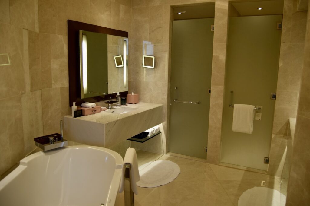 Wand, Im Haus, Installationszubehör, Badezimmerzubehör, Hotel, Hahn, Badezimmer, Wasserleitung, Kachel, Waschbecken, Inneneinrichtung, Badezimmerschrank, Spiegel, Boden, Wanne, Toilette, Badewanne, Zimmer, Dusche